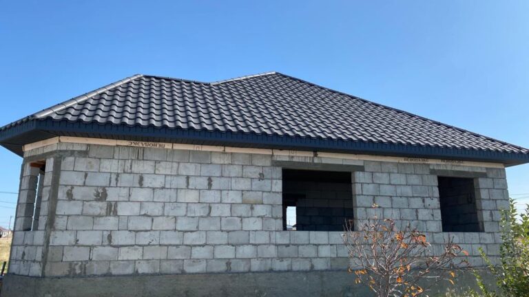 Кровля из металлочерепицы над стеной из блоков, вид крупным планом